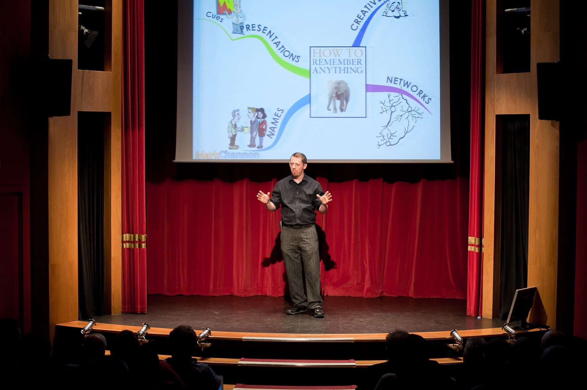 Mark Channon on a theatre stage in front of a full audience